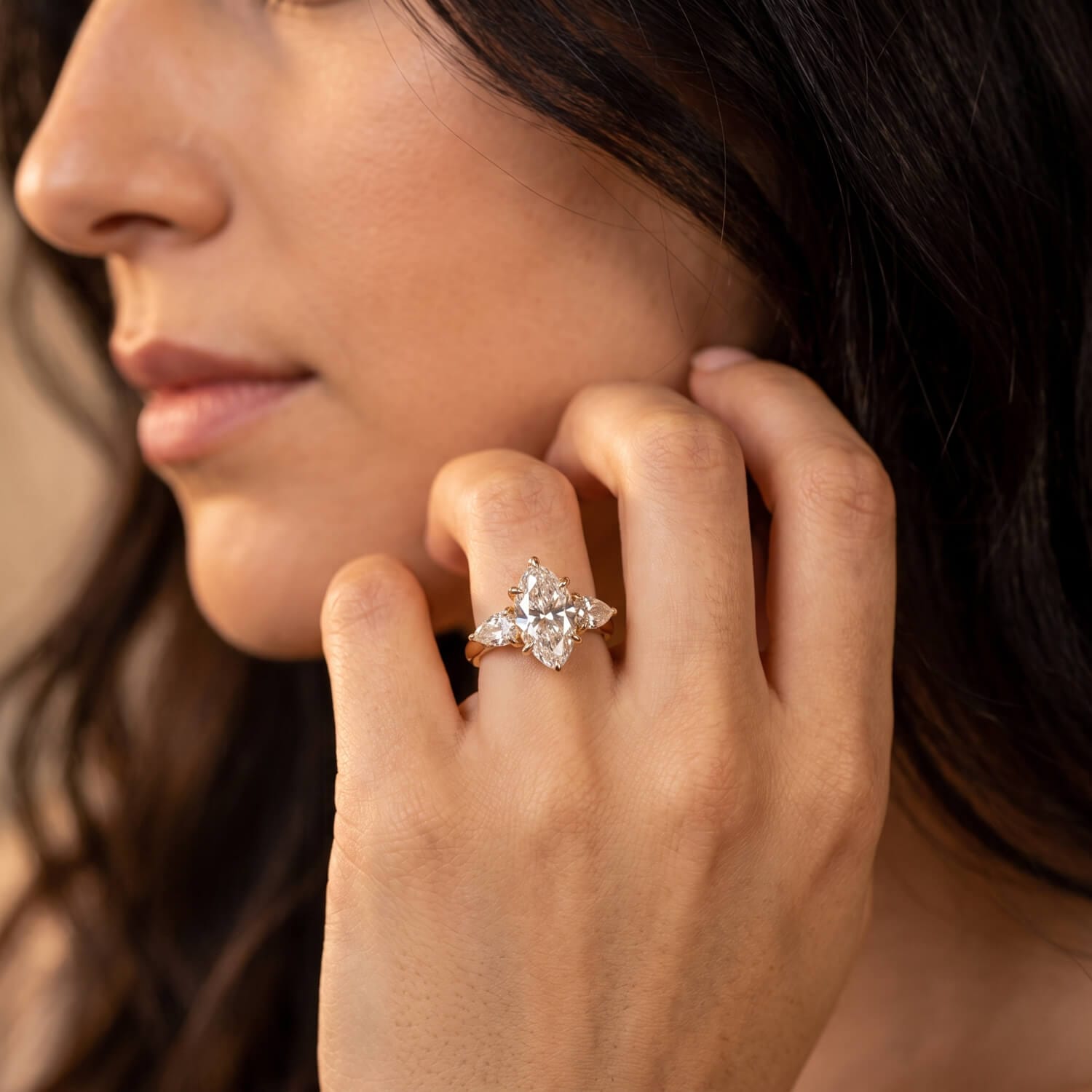 Pear-shaped side diamonds framing an elongated oval center