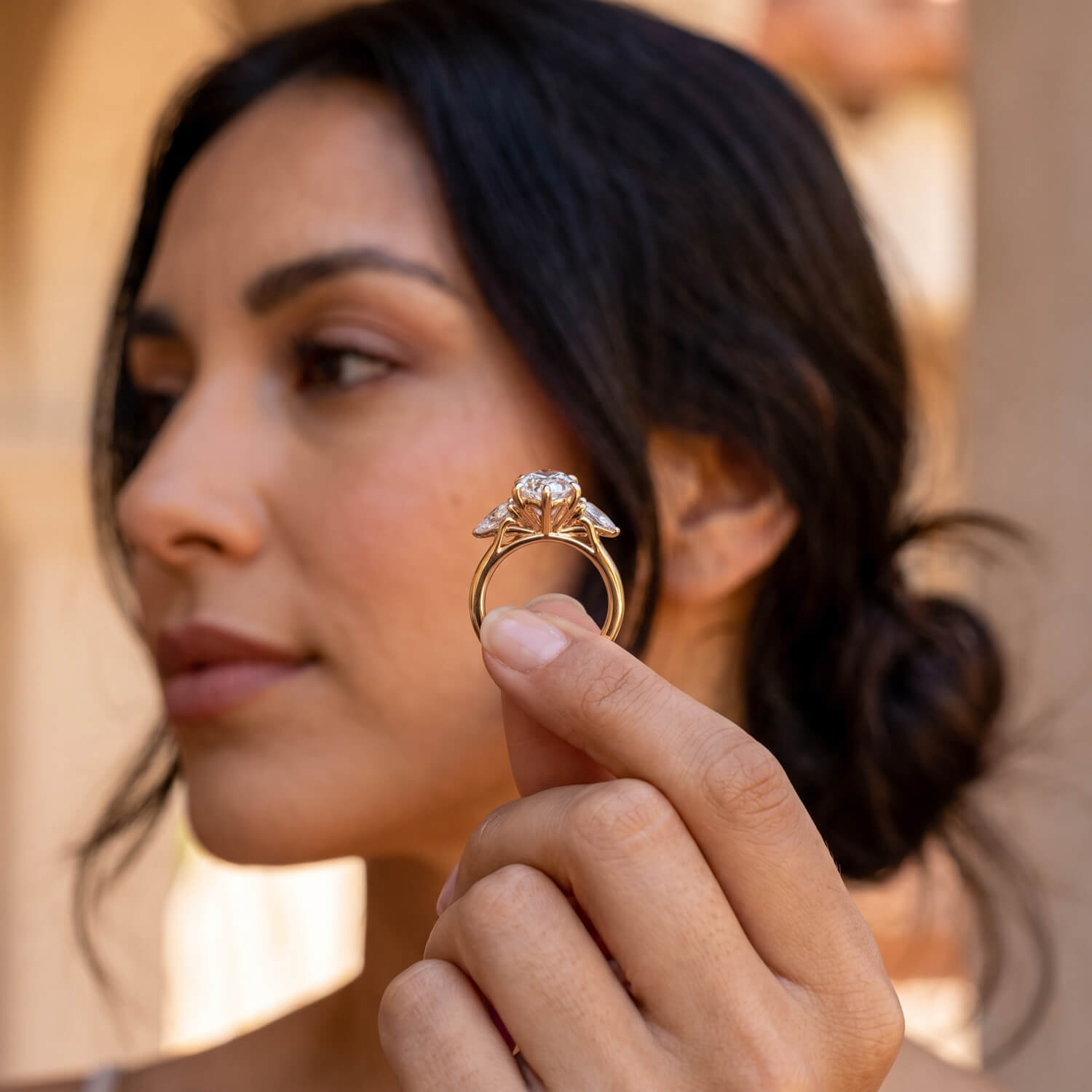 Elongated oval three-stone engagement ring worn on hand