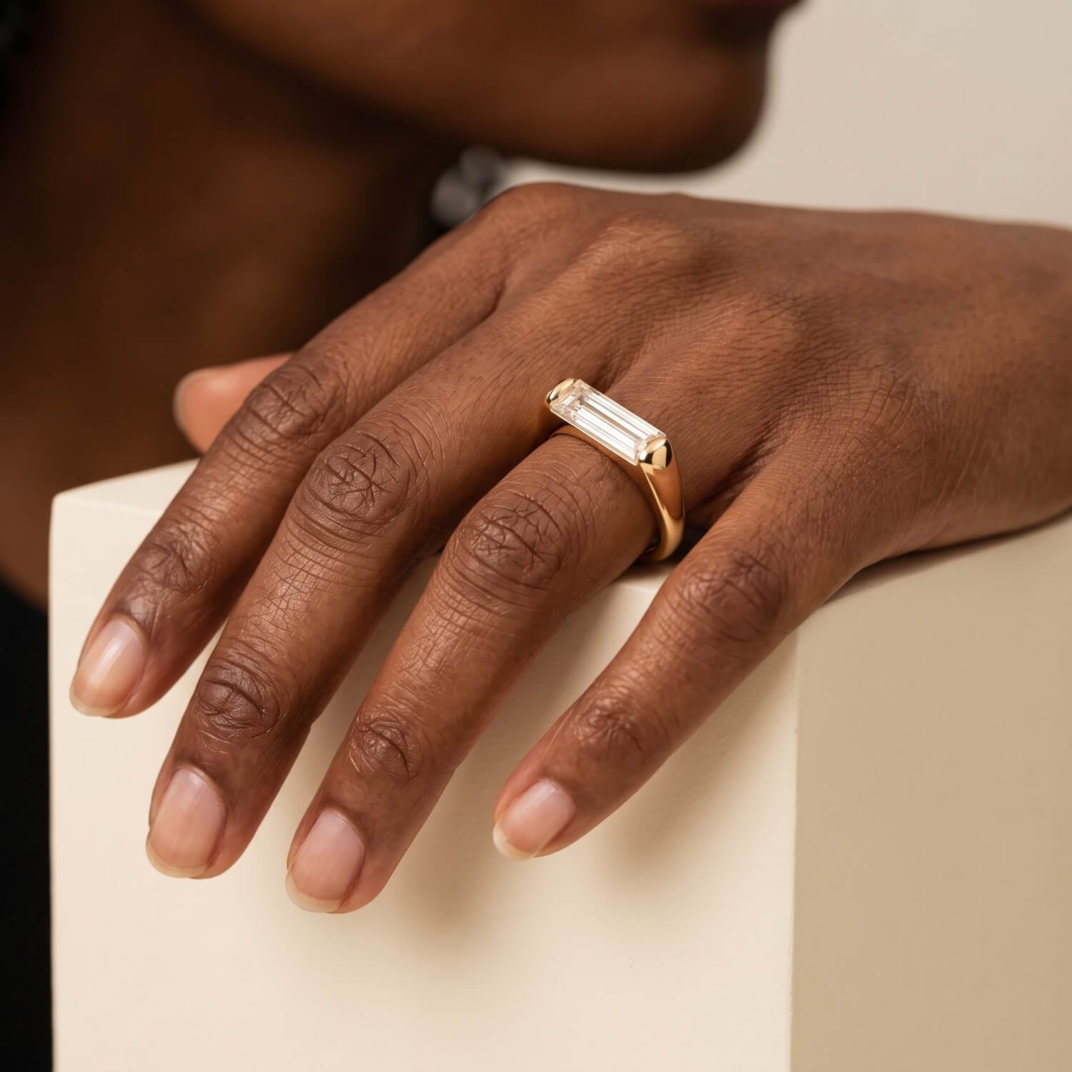 Custom baguette diamond solitaire engagement ring on hand