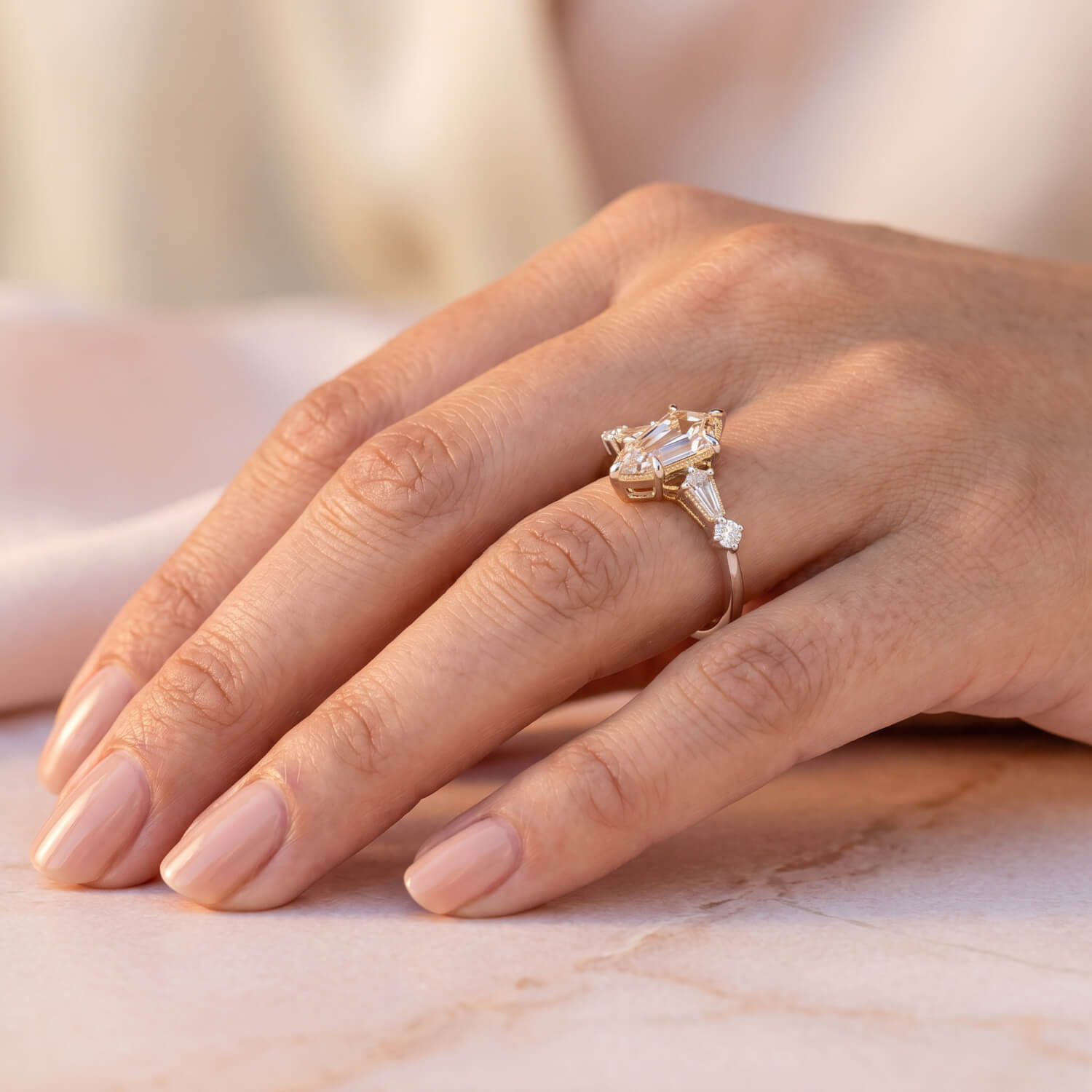 Kite-shaped diamond engagement ring worn on hand