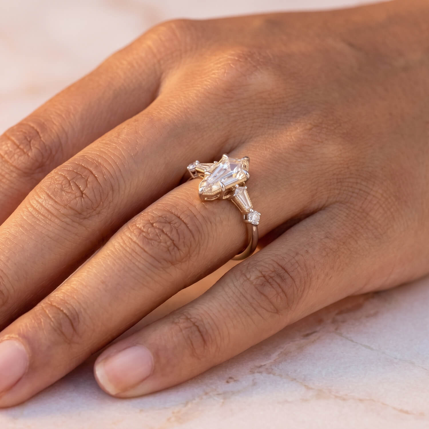 Mixed-metal kite diamond engagement ring worn on hand